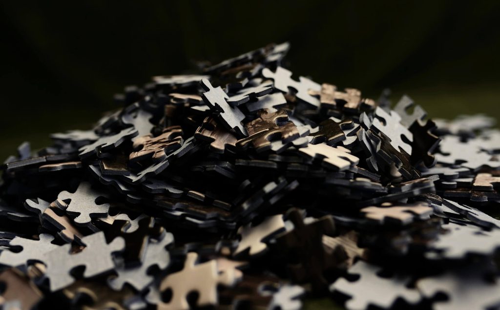 A scattered pile of dark puzzle pieces symbolizing the feeling of being disconnected from life.