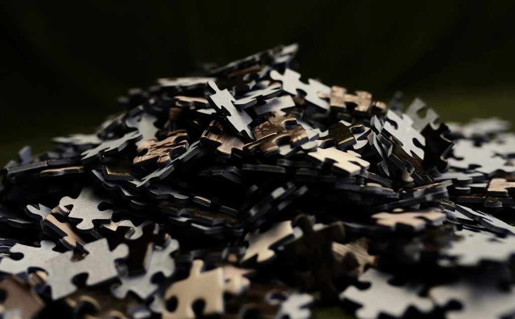 A scattered pile of dark puzzle pieces symbolizing the feeling of being disconnected from life.
