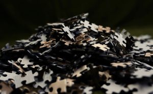 A scattered pile of dark puzzle pieces symbolizing the feeling of being disconnected from life.
