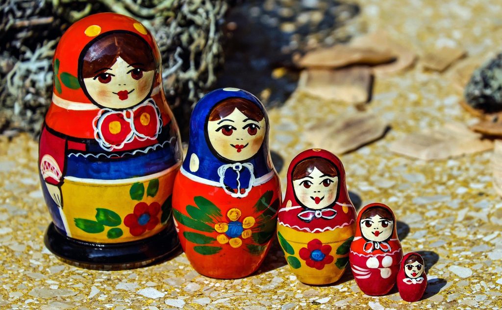 Five colorful matryoshka nesting dolls lined up by size to visually represent different stages and layers of emotional regulation techniques.